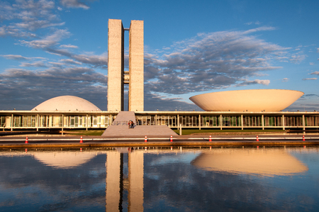 Brasilia, Brazil - June 3, 2015: Brazilian National Congress reflected on water by sunset. The building was designed by Oscar Niemeyer in the modern Brazilian style.のeditorial素材
