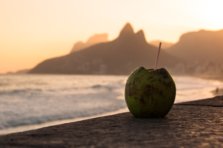 Coconut drink on the ground in Ipanema beach by sunset, Rio de Janeiro, Brazilの写真素材
