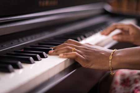 Dark Skin Female Hands Playing Piano Keyboardの写真素材