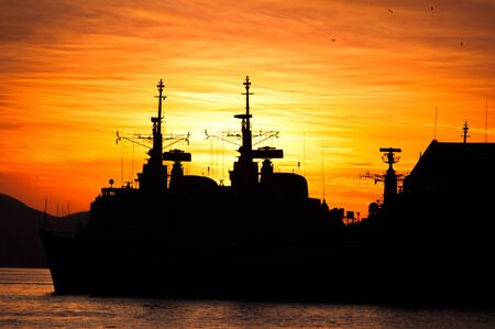 Two Military Navy Ships Silhouettes by Sunsetの写真素材