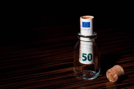Rolled 50 Euro Banknote Inside a Small Glass Bottle, Saving Moneyの写真素材