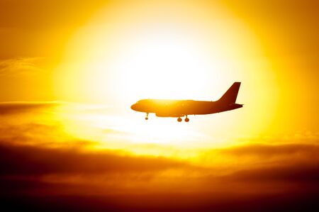 Passenger Aircraft Silhouette With Sun Shining Behindの写真素材