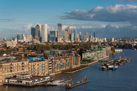 View of Residential Buildings in Front of Thames River and Canary Wharf District in the Horizon, in London, UKの写真素材