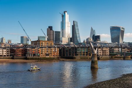 Tall Buildings in City of London Financial District and the Millennium Bridge Crossing Thames Riverの写真素材