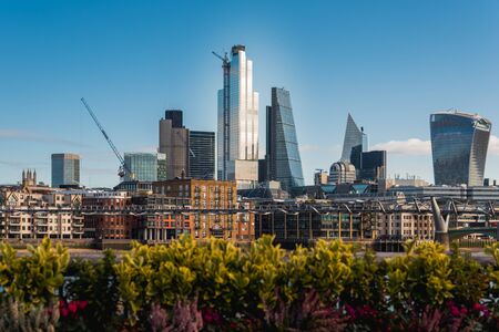 Tall Buildings in City of London Financial District and the Millennium Bridge Crossing Thames River