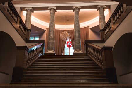 Interior of Vilnius City Town Hall. Staircase leading to the columns, and window with curtains, with...