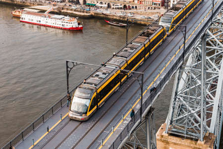 Vila Nova de Gaia, Portugal - November 20, 2019: Subway metro crossing slowly the famous Luis I Bridge.のeditorial素材