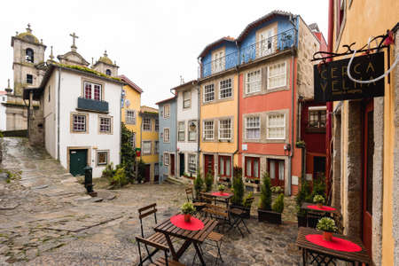 Porto, Portugal - November 19, 2019: Outdoor cafeteria in a square with colorful houses in the...