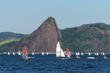Rio de Janeiro, Brazil - December 4, 2020: A bunch of white sailboats riding in Guanabara bay with mountain landscape in the horizon.のeditorial素材