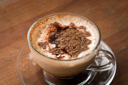 Glass Cup of Cappuccino Coffee on Wooden Tableの写真素材