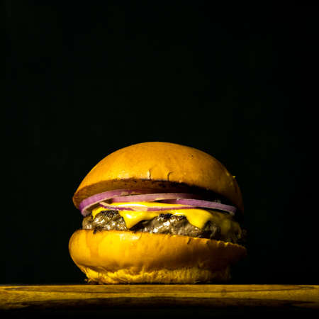 Tasty Fresh Home Made Gourmet Burger on Wooden Table With Dark Backgroundの写真素材