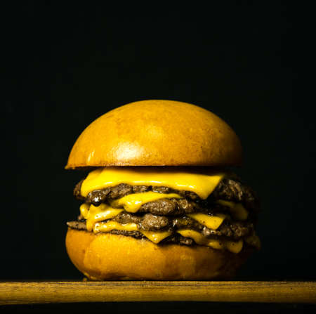 Tasty Fresh Home Made Gourmet Burger on Wooden Table With Dark Backgroundの写真素材