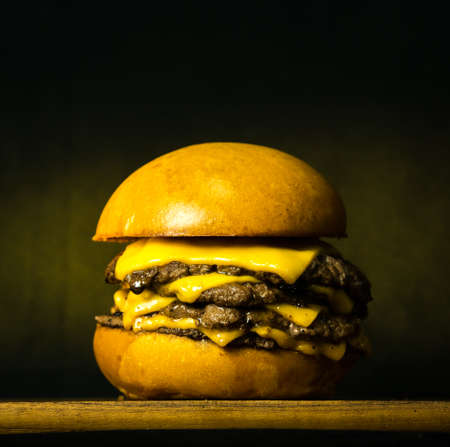 Tasty Fresh Home Made Gourmet Burger on Wooden Table With Dark Backgroundの写真素材
