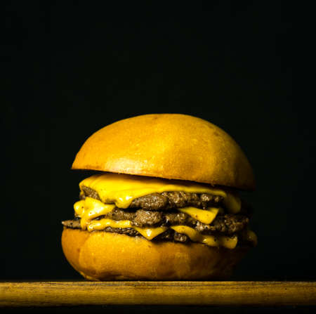 Tasty Fresh Home Made Gourmet Burger on Wooden Table With Dark Backgroundの写真素材