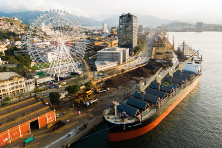 Rio de Janeiro, Brazil - August 3, 2022: Aerial view of Yup Star (Rio Star) ferris wheel and large industrial cargo ship.のeditorial素材