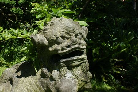 Stone statue of a lion in japanese gardenの写真素材
