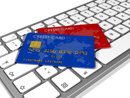 blue and red credit cards on a computer keyboardの写真素材