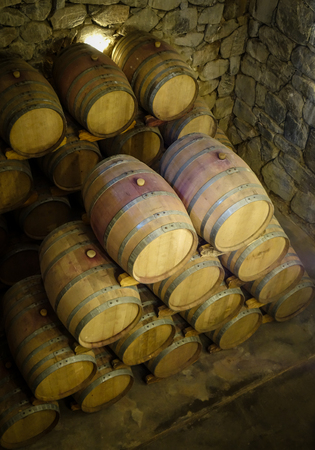 rows of wood wine barrels in a vintage winery caveの写真素材