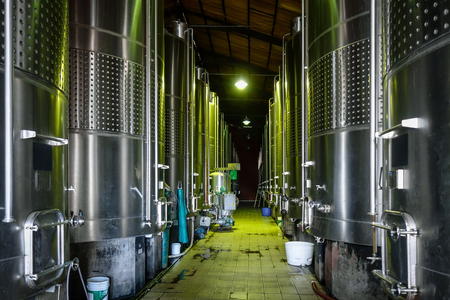rows of metal wine barrels in a wineryの写真素材