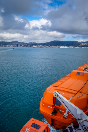 Wellington city and orange lifeboat view from a ferry. New Zealand north Islandの写真素材