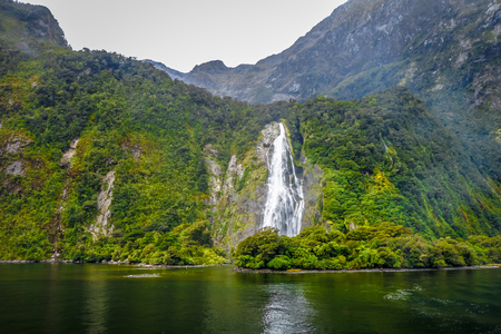 Waterfall in Milford Sound lake landscape, New Zealandの写真素材