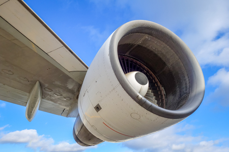 Airplane engine and wing on airport tarmac. Blue skyの写真素材