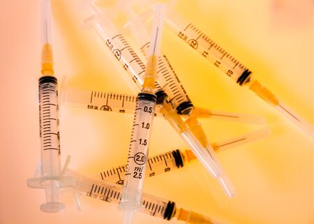 Group of syringes on orange backgroundの写真素材
