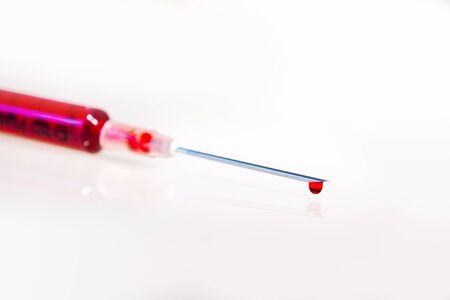 Syringe with blood closeup on white backgroundの写真素材