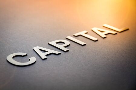 Word capital written with white solid letters on a boardの写真素材