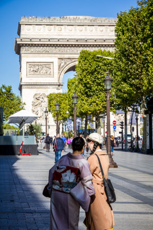 Paris/France - September 10, 2019 : Two Japanese tourist taking pictures in front of the Arc de Triomphe on Champs-Elysees avenueのeditorial素材