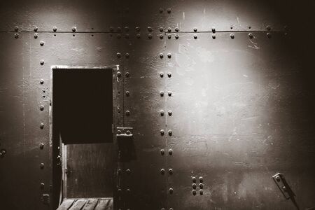 Dark metal wall and door in a war bunker. Black and white photographyの写真素材