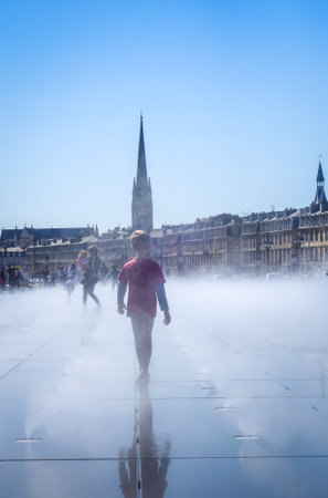 Bordeaux/France - April 17, 2018 : Children playing in Water Mirror.のeditorial素材
