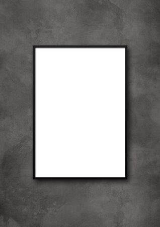 Black picture frame hanging on a dark concrete wall. Blank mockup templateの写真素材