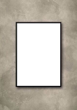 Black picture frame hanging on a light concrete wall. Blank mockup templateの写真素材