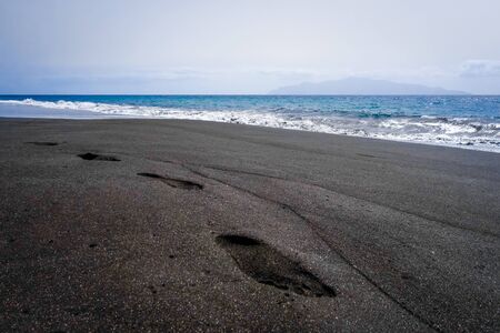 Footprints in black sand beach, Fogo Island, Cape Verde, Africaの写真素材