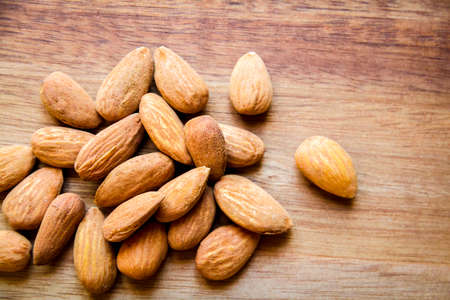 Fresh organic almonds on a wooden cutting board. Top viewの写真素材