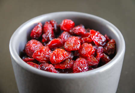 Cranberries in a bowl on a black kitchen table.の写真素材