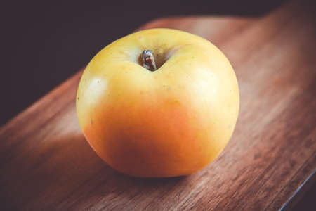 Organic fresh apple on wooden cutting boardの写真素材