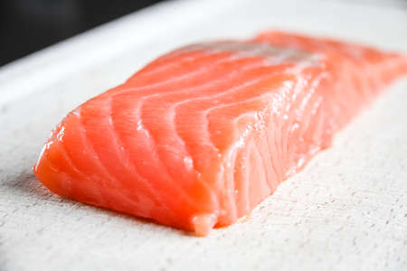 Salmon steak on a wooden cutting board. Close-up viewの写真素材
