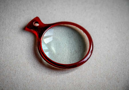 Magnifying glass closeup view on a paper backgroundの写真素材