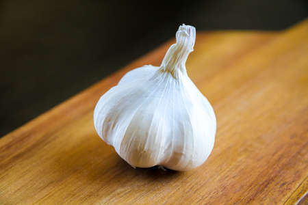 Organic fresh clove garlic on a wooden cutting board