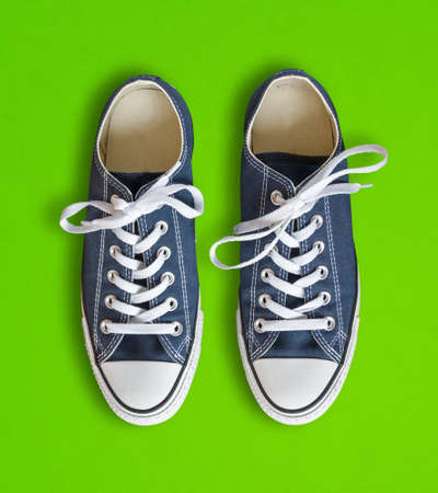 Blue generic sneakers isolated on green backgroundの写真素材