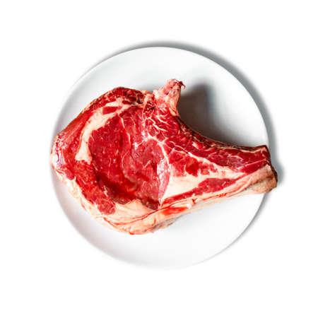 Raw beef prime rib on a plate isolated on white background. Top viewの写真素材