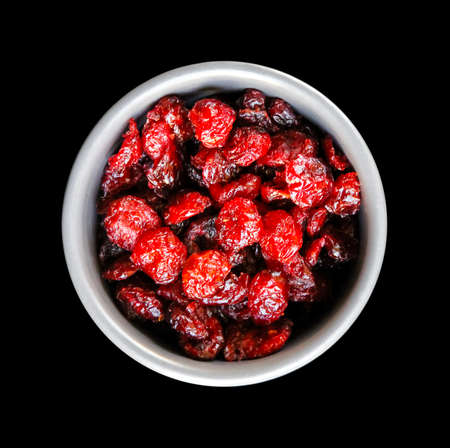 Cranberries in a bowl isolated on black background. Top viewの写真素材