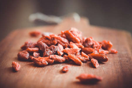 Goji berries on a wooden cutting boardの写真素材