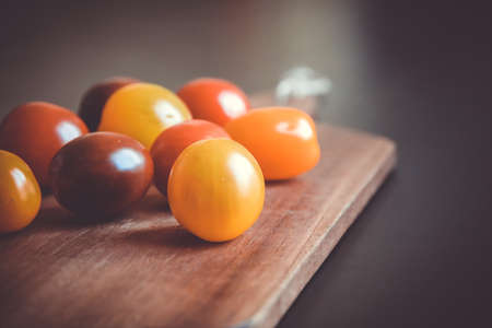 Colorful cocktail tomatoes on a wooden cutting board