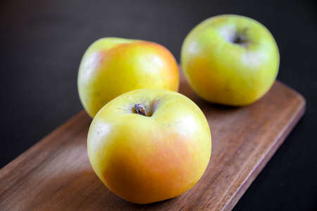 Organic fresh apples on wooden cutting boardの写真素材