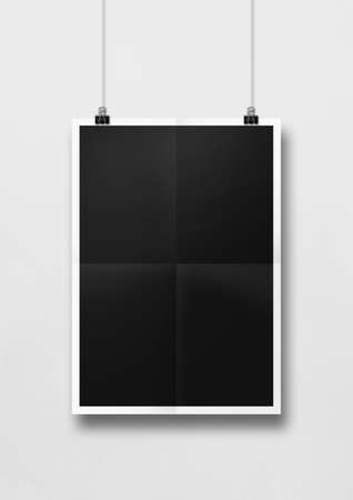Black folded poster hanging on a white wall with clips. Blank mockup templateの写真素材