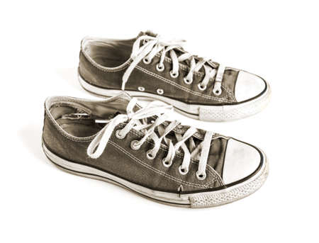 Old black generic sneakers isolated on white backgroundの写真素材