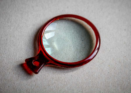 Magnifying glass closeup view on a paper backgroundの写真素材